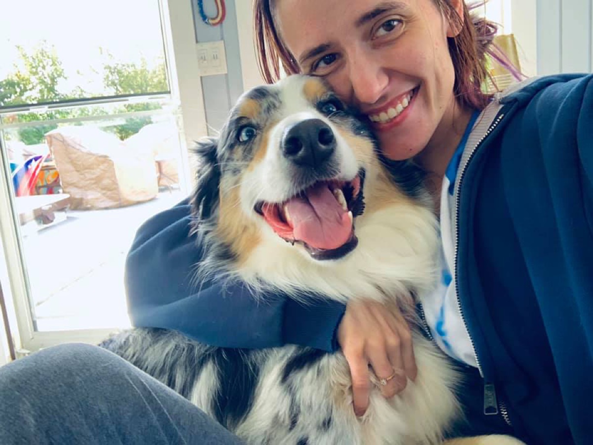 Sam holding an Australian Shepherd